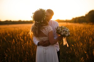 man and woman standing in front of brown grass field kissing 1573007